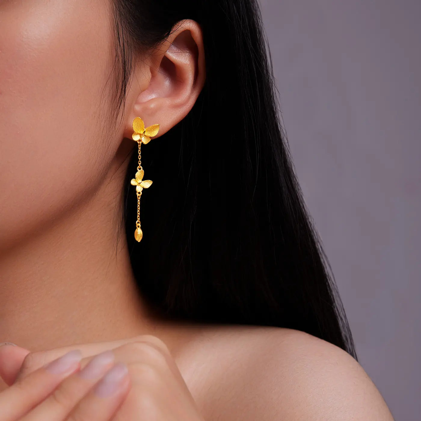 Sunfeel 24k Gold butterfly & bud dangle earrings worn by a person